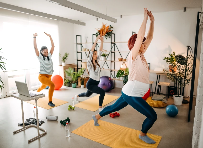 Three women doing yoga poses indoors